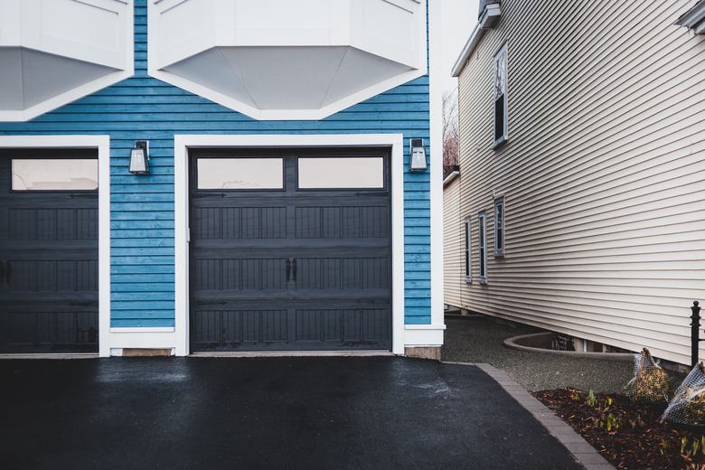 Porte de garage sectionnelle sombre sur une façade bleue