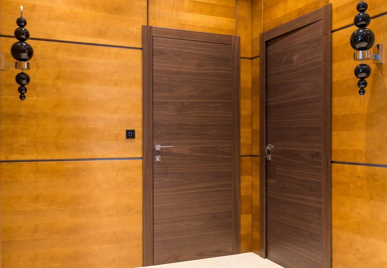 Deux portes intérieures en bois sur un mur en lambris